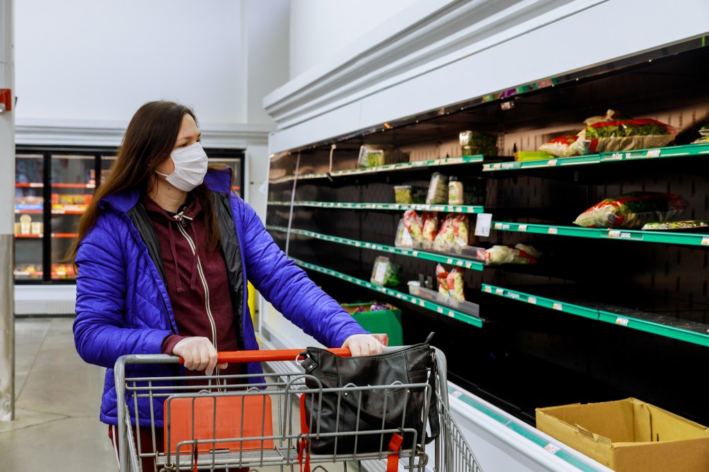 Woman with protection face mask and gloves shopping at supermarket. Coronavirus concept.