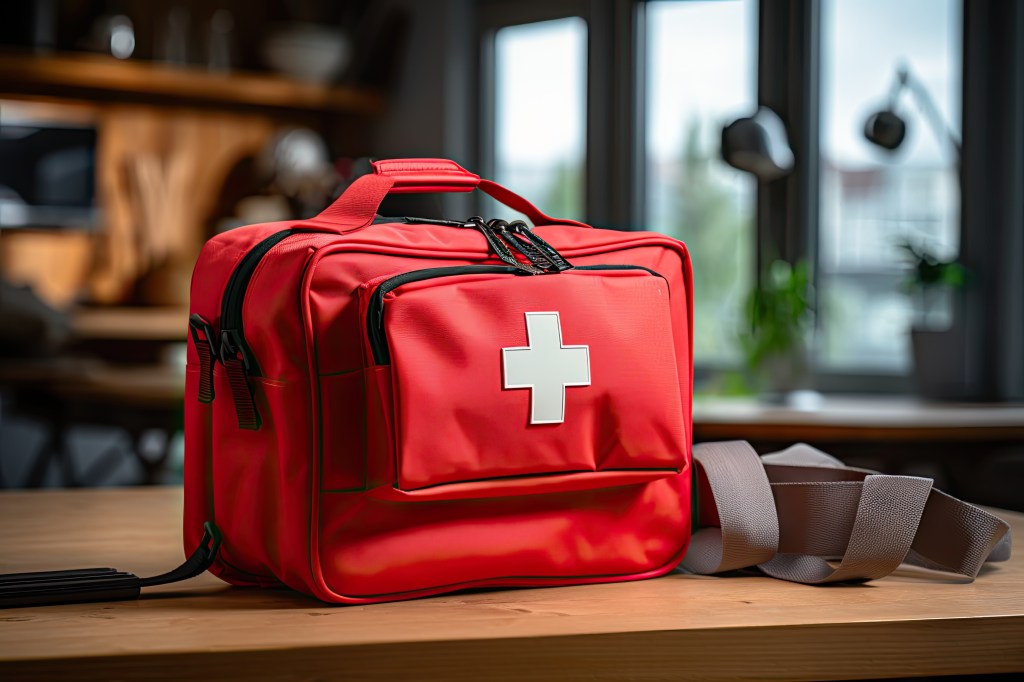 Red first aid bag on a wooden table